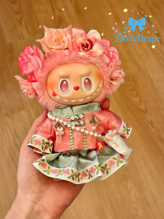 Hand holding Labubu plush in blossom crown dress front view